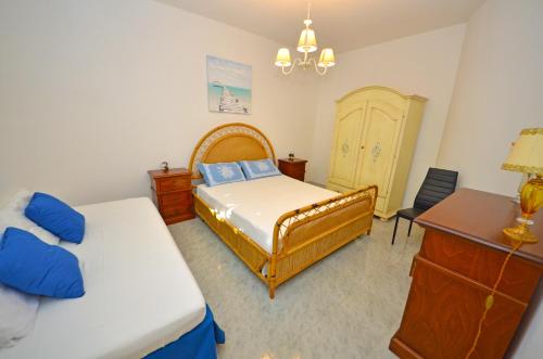a bedroom with two beds and a dresser and a desk at Casa Baia Tramonto in Patù