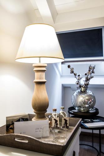a table with a lamp on top of a table at Meltar Boutique Hotel Golf & SPA in Asiago
