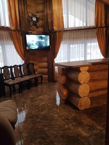 a living room with a table and chairs and a tv at Зимова казка in Tatariv