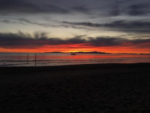 a sunset on a beach with a cloudy sky at Podere Mammoleta in Fattoria Marsiliana