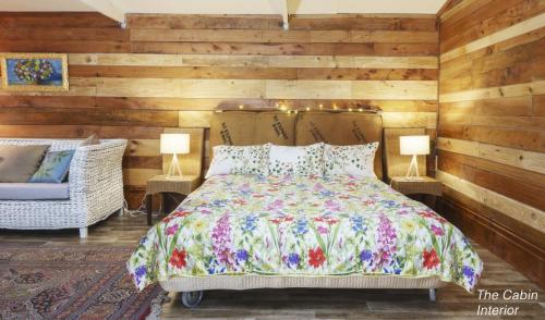 a bedroom with a bed and a chair and two lamps at Tracy's Boutique B&B Farmstay in Wellsford