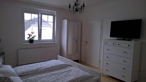 a bedroom with a bed and a television on a dresser at Rosenappartement-Deutschkreutz in Deutschkreutz