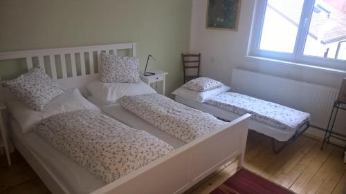 a room with three beds and a window at Rosenappartement-Deutschkreutz in Deutschkreutz