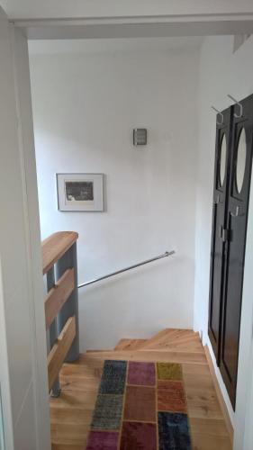 a room with a black refrigerator and a wooden floor at Rosenappartement-Deutschkreutz in Deutschkreutz