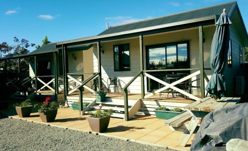 a house with a patio and an umbrella at Rosedale Cottages in Twizel