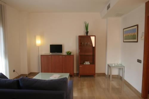 Una sala de estar con un sofá y un televisor. en Apartaments Aragó565, en Barcelona