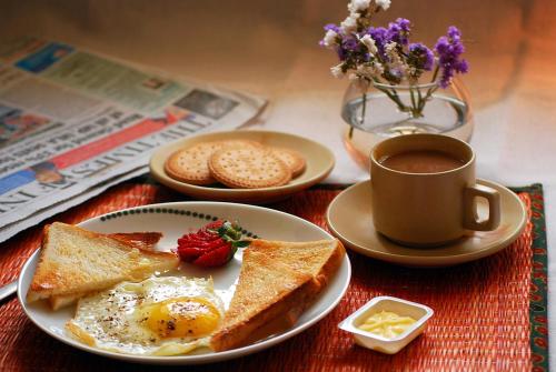 un plato de huevos y tostadas y una taza de café en Royal Residency, en Nueva Delhi