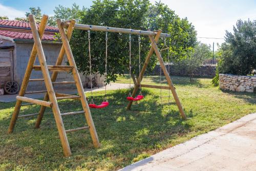 a swing set with red shoes sitting in a yard at Rural House Kod Slapa in Bogatić