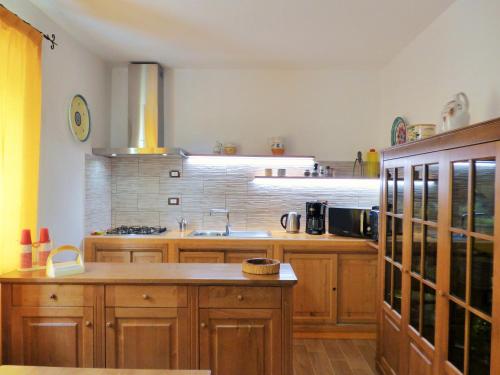 a large kitchen with wooden cabinets and a sink at Villa Maria in Patti
