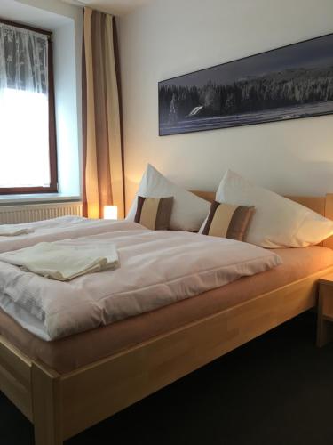 a large bed in a room with a window at Penzion Na Solné stezce in Kašperské Hory