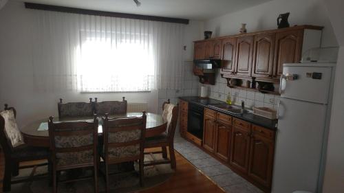 庫普雷斯的住宿－Apartmani Matko，厨房配有桌子和白色冰箱。