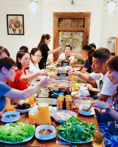 a group of people sitting around a table eating food at Kaya Residence Kandy in Kandy