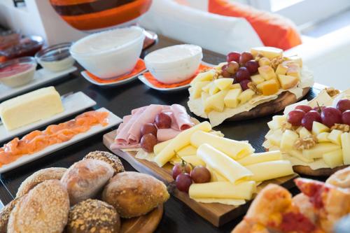 a table topped with different types of cheese and pastries at Lu' Hotel Riviera - Carloforte in Carloforte
