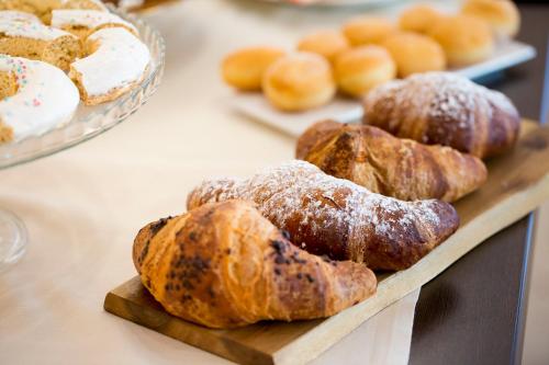 a bunch of pastries on a wooden tray on a table at Lu' Hotel Riviera - Carloforte in Carloforte