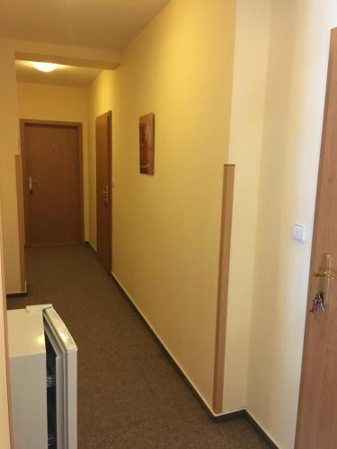 an empty hallway with yellow walls and a door at Penzion Na Solné stezce in Kašperské Hory