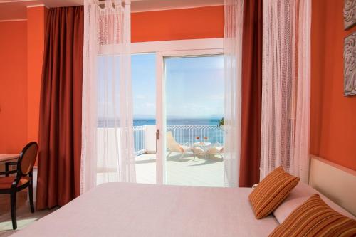 sypialnia z łóżkiem i widokiem na ocean w obiekcie Lu' Hotel Riviera w mieście Carloforte