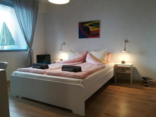 een groot wit bed in een kamer met een raam bij Apartment 17 in Velingrad