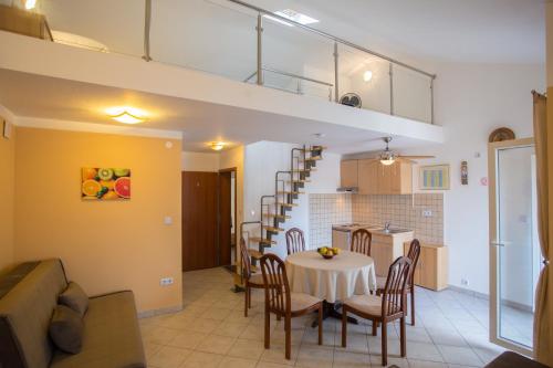 a living room and kitchen with a table and chairs at Apartment Smuljic in Vrboska