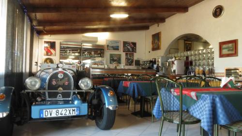 an old car parked in a restaurant with tables at Hotel Chopin in Fiumicino