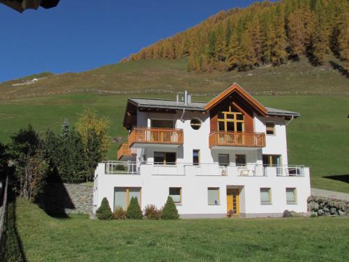 a white house with a balcony on a hill at Apartment MEZPRA in Samnaun