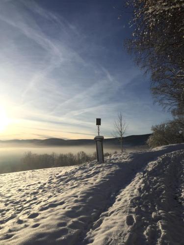 a snow covered hill with a sign on top of it at Penzion Na Solné stezce in Kašperské Hory