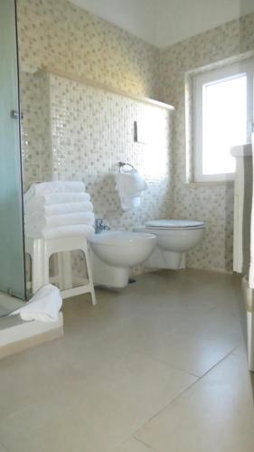 a bathroom with two sinks and a tub and a toilet at Hotel Chopin in Fiumicino