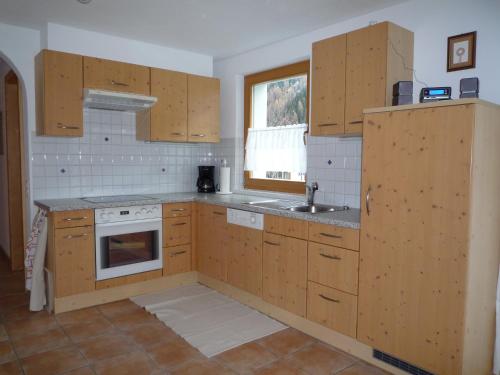 a kitchen with wooden cabinets and a sink at Apartment MEZPRA in Samnaun