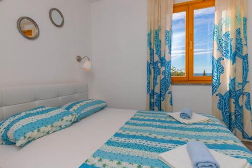 a white bedroom with a bed and a window at Apartments Maris in Crikvenica