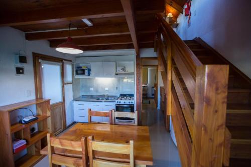 ディナ・ウアピにあるCasa Rojaの部屋に木製のテーブルと椅子が置かれたキッチン