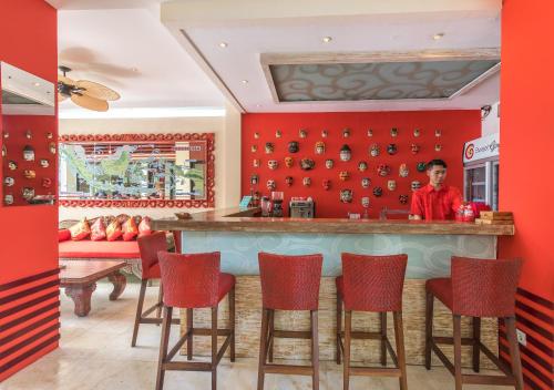 a bar in a restaurant with red walls at Bali Ginger Suites & Villa in Seminyak
