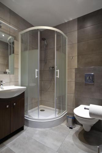 a bathroom with a shower and a toilet and a sink at Apartamenty TRZY KOLORY in Szklarska Poręba