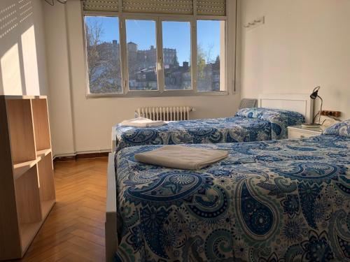 Habitación con 2 camas y ventana en Hostal Costa Azul, en Santiago de Compostela