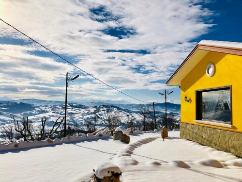 a yellow building with snow on the ground at Villa Aurora in Villanova del Battista