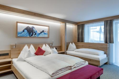 a hotel room with two beds and a window at Frühstückspension Broser in Obergurgl