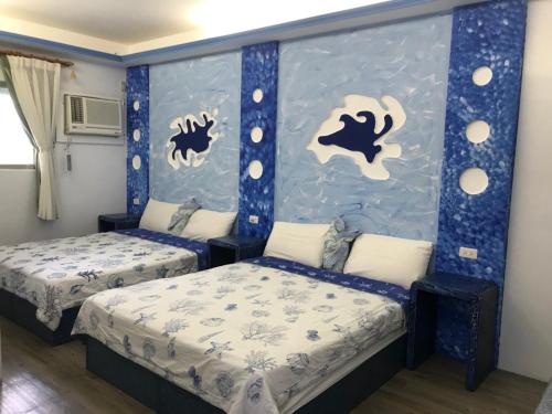 a bedroom with two beds and a wall with bubbles at Country Kos Hostel in Kenting