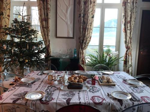 una mesa de comedor con un árbol de Navidad. en Château de Druon en Sévignacq-Meyracq