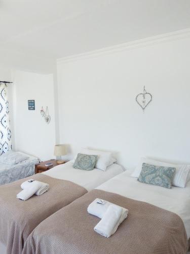 two beds in a room with towels on them at Kairos Cottage B&B in Lüderitz