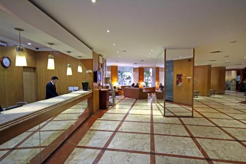 a man in a suit standing in a hotel lobby at San Raphael Hotel in Sao Paulo