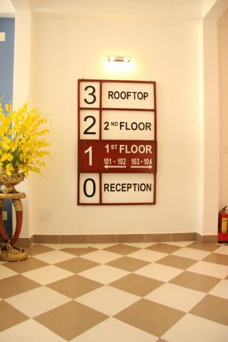 a sign on a wall in a room with a checkered floor at Queenie House in Can Tho