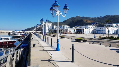 a street light next to a harbor with boats at Jolie appartement vue mer in M'diq