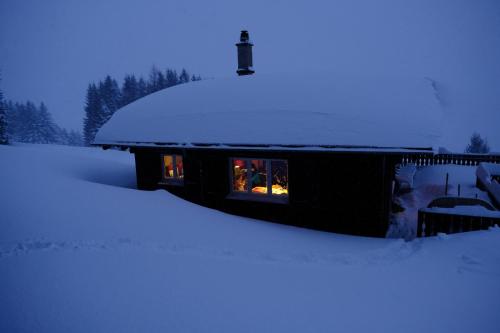 a house covered in snow with a window at Chalet Casa Cresta - Top of Lenzerheide - bis 8 Personen in Valbella