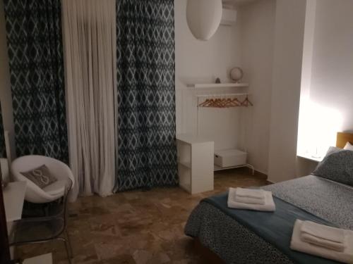 a bedroom with a bed and a chair and a window at B&B La Terrazza Near The Beach in Bari