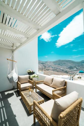 a living room with wicker furniture and a large window at Plori Studios and Apartments in Aegiali