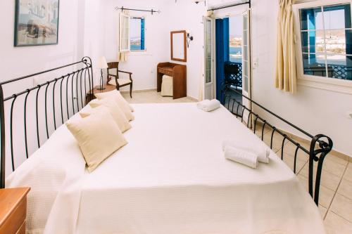 a bedroom with a large white bed in a room at Akrotiri in Analipsi