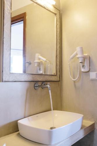 a white sink in a bathroom with a mirror at Akrotiri in Analipsi