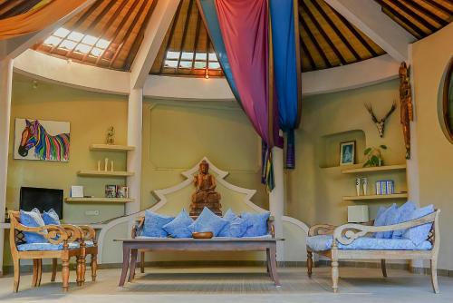 a room with two chairs and a table with blue pillows at Ben Bali Villa in Seminyak