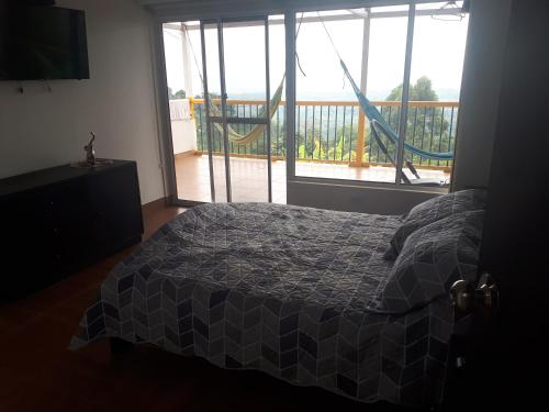 sypialnia z łóżkiem i dużym oknem w obiekcie Finca Bella Vista w mieście Calarcá