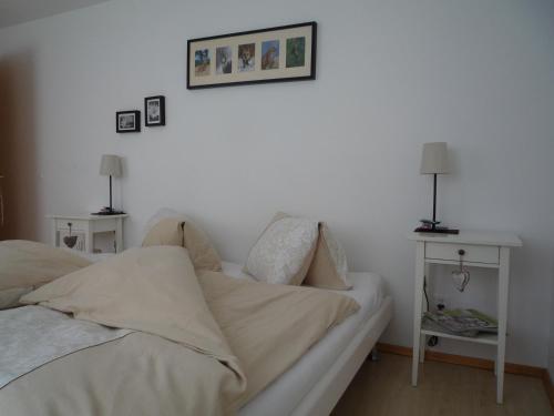 a bedroom with two beds and two tables with lamps at Apartment MEZPRA in Samnaun