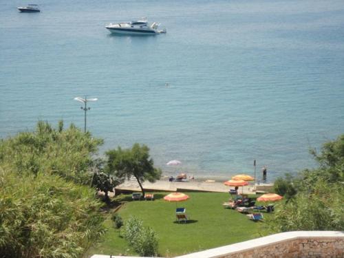 a beach with umbrellas and a boat in the water at Casa Baia Tramonto in Patù