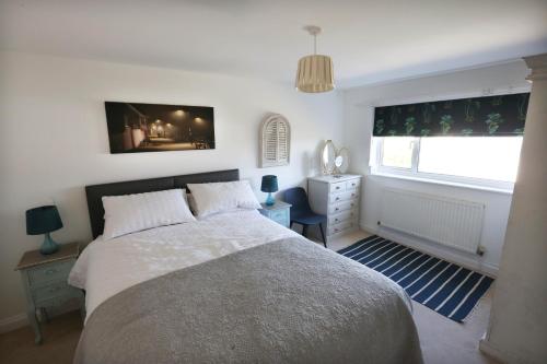 um quarto com uma cama grande e uma janela em 4a Dolphin Close em Lyme Regis